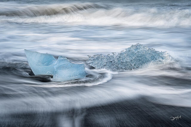Ancient chunks of blue ice stranded on the black sand of Diamond Beach in Iceland.
