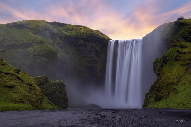 Skógafoss waterfall at sunset in Iceland.