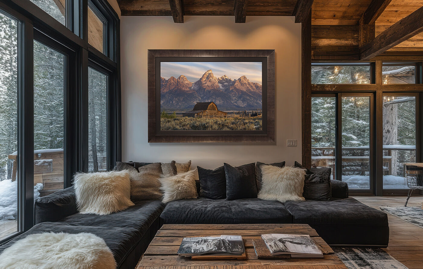 A large Roma framed photograph of John Moulton Barn hangs on a wall over a sofa in a modern rustic mountain home.
