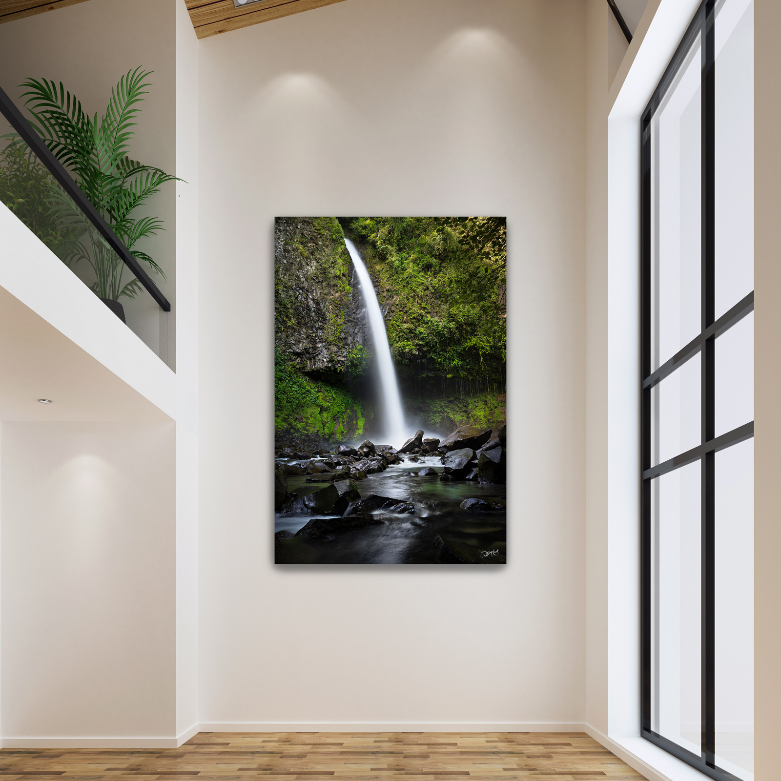A large photographic print of La Fortuna waterfall in Costa Rica hangs on a feature wall in an upscale home.
