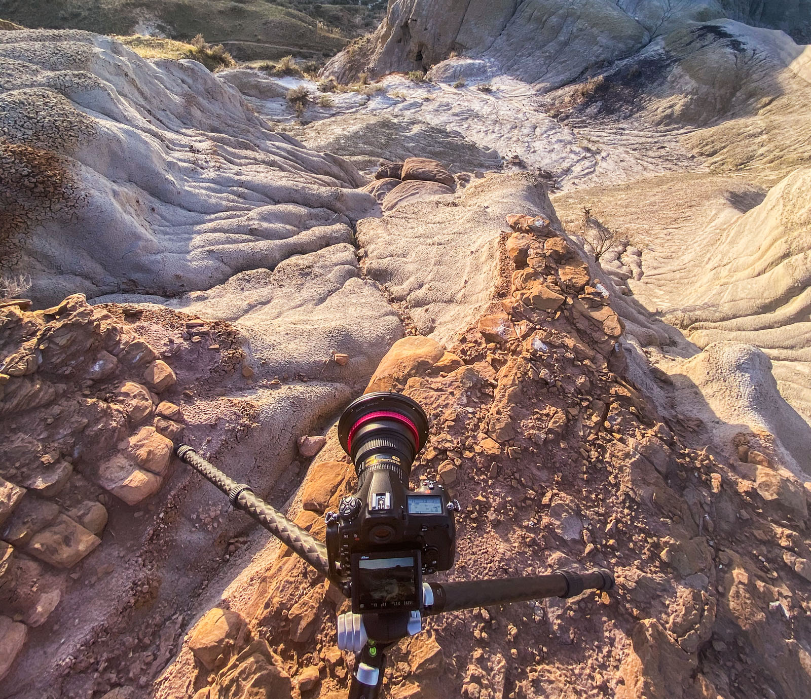 Camera on tripod set up in the badlands before sunset for landscape photography composition.