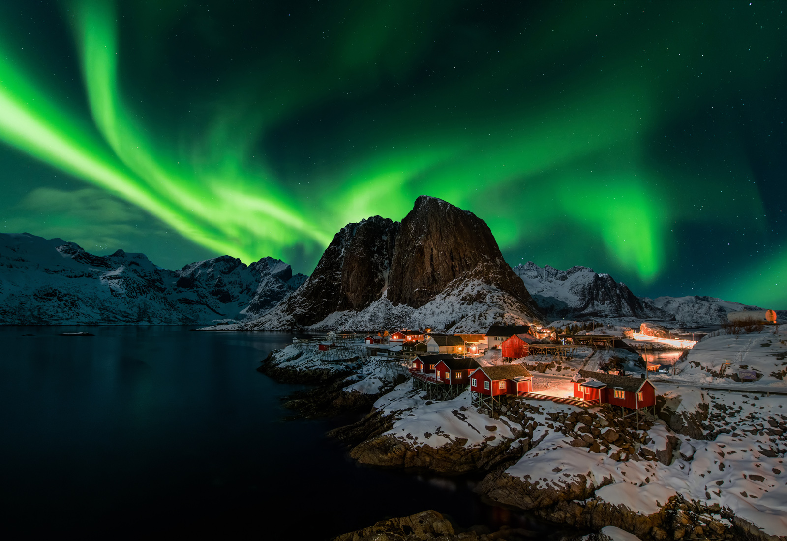 The small fishing village Hamnoy, Norway in the winter at night under a sky filled with Northern lights.
