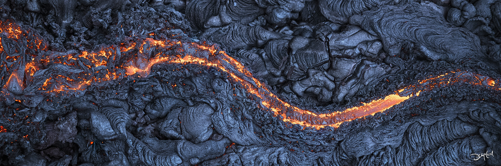 Aerial view of lava flow in Hawaii with glowing molten rock, panoramic fine art landscape photography print.