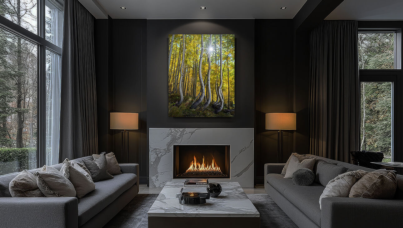 Alt text: Vertical Lumachrome® acrylic photograph of aspen trees illuminated by accent lighting above a fireplace in an upscale contemporary living room.